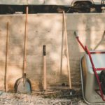 Gardening Tools - red and black shovel beside brown wooden stick
