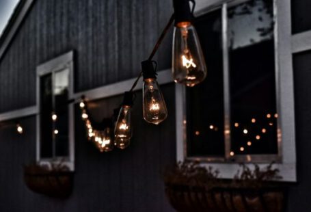 Outdoor Lighting - piled hanging lighted bulb beside house
